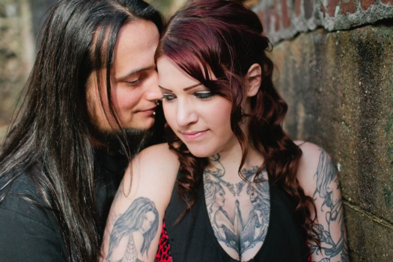 tattooed couple poses for engagement photos for markow photography at an abandoned site
