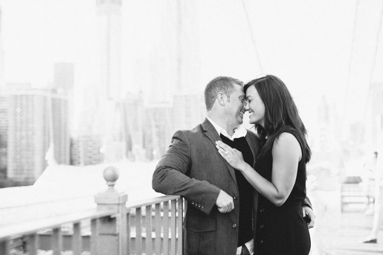 couple on brookyln bridge for engagement photo session with nyc wedding photographers