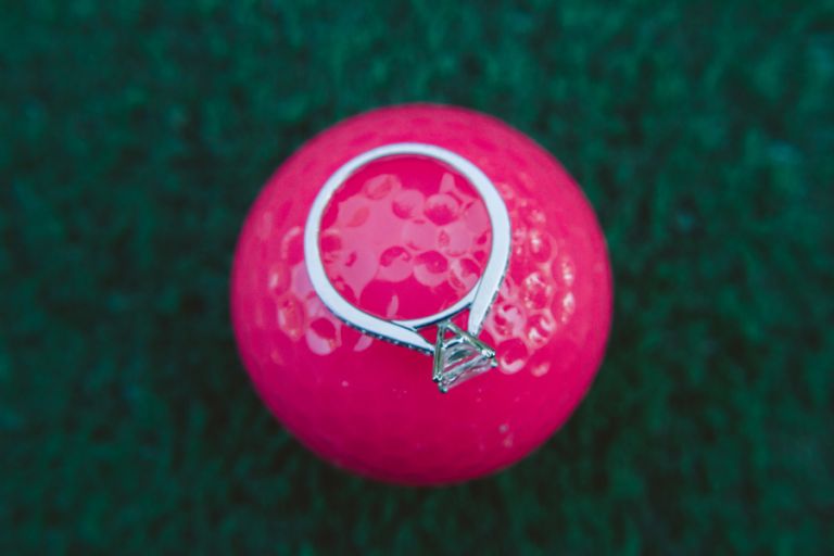 engagement ring on golf ball during engagement photo session in Monmouth County NJ