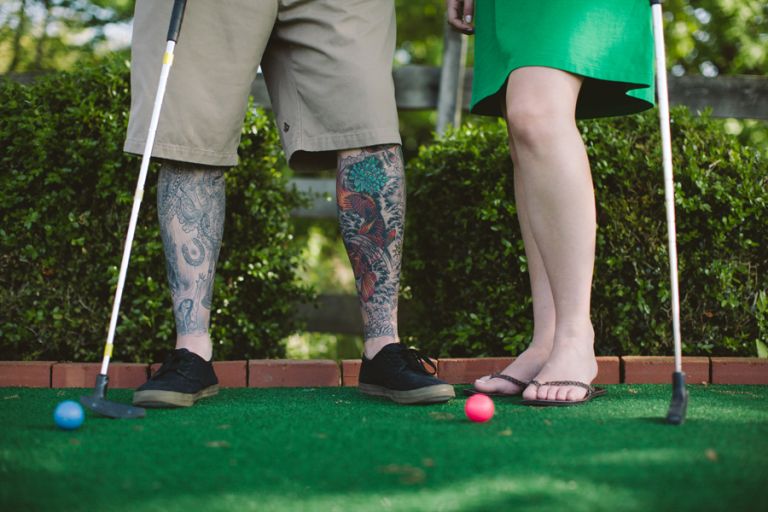 couple plays mini golf during engagement session with monmouth county wedding photographers