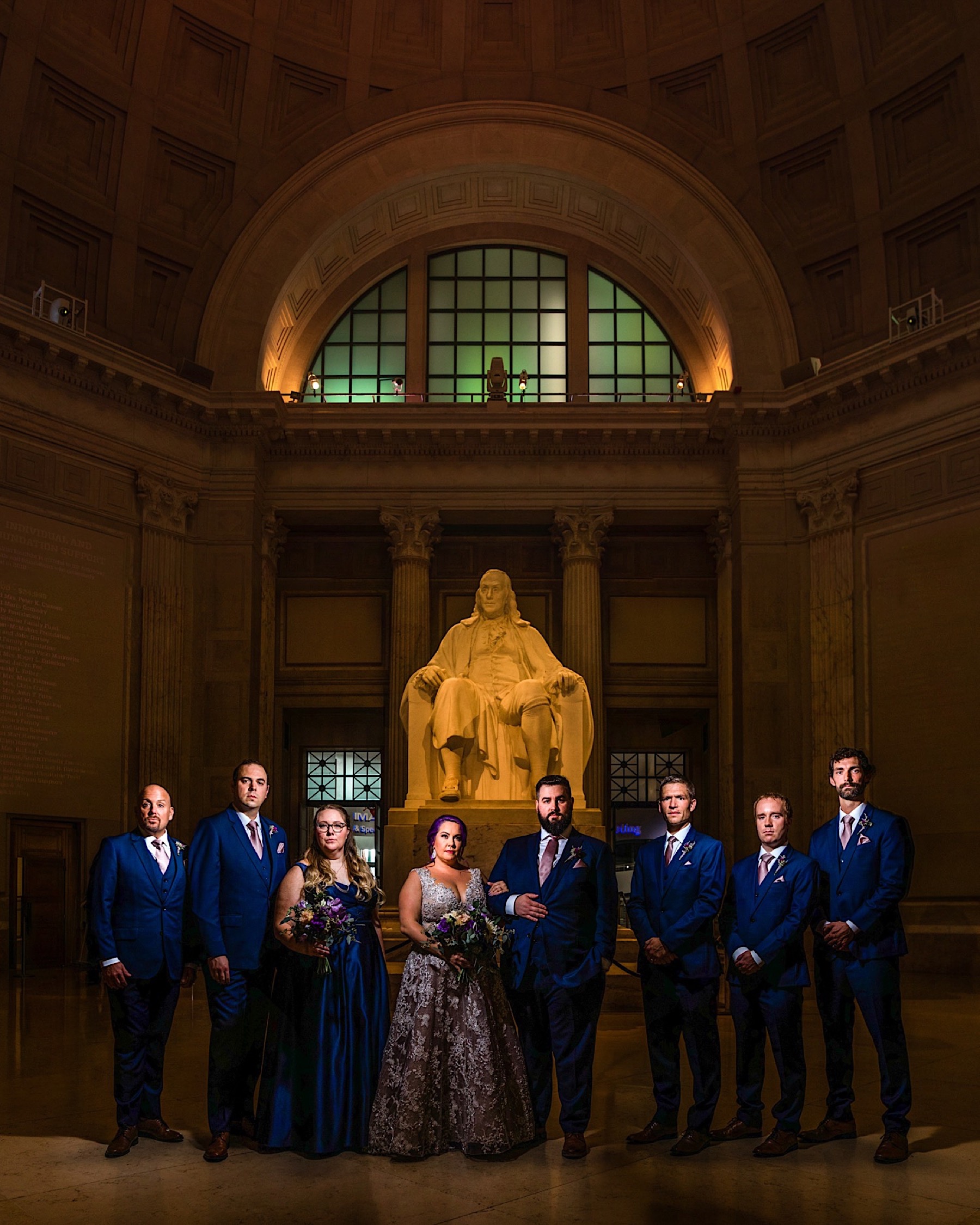 bridal party in front of ben Franklin statue at franklin institute